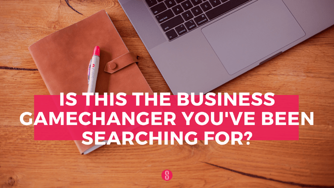 A desk with a closed notebook, a laptop, and a pink pen, with text asking if this is the business gamechanger you've been searching for