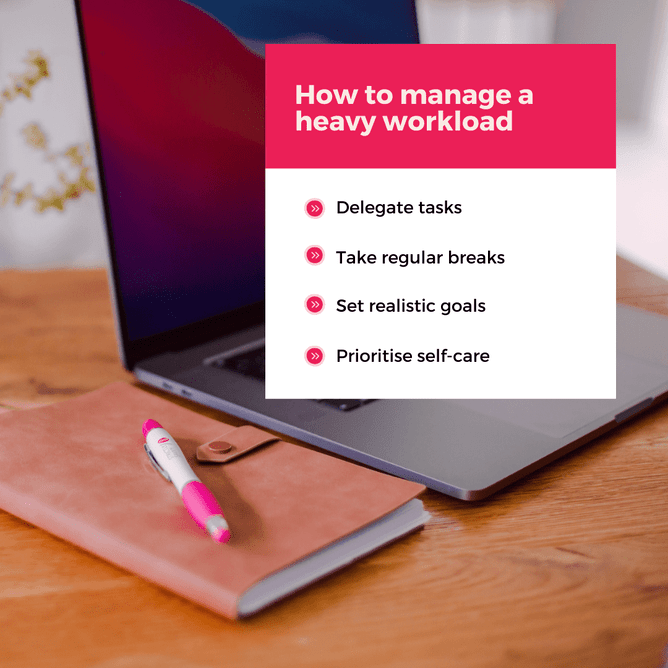 Pink and white graphic showcasing tips for managing a heavy workload, with a laptop, pen, and notebook on a wooden desk in the soft-focus background