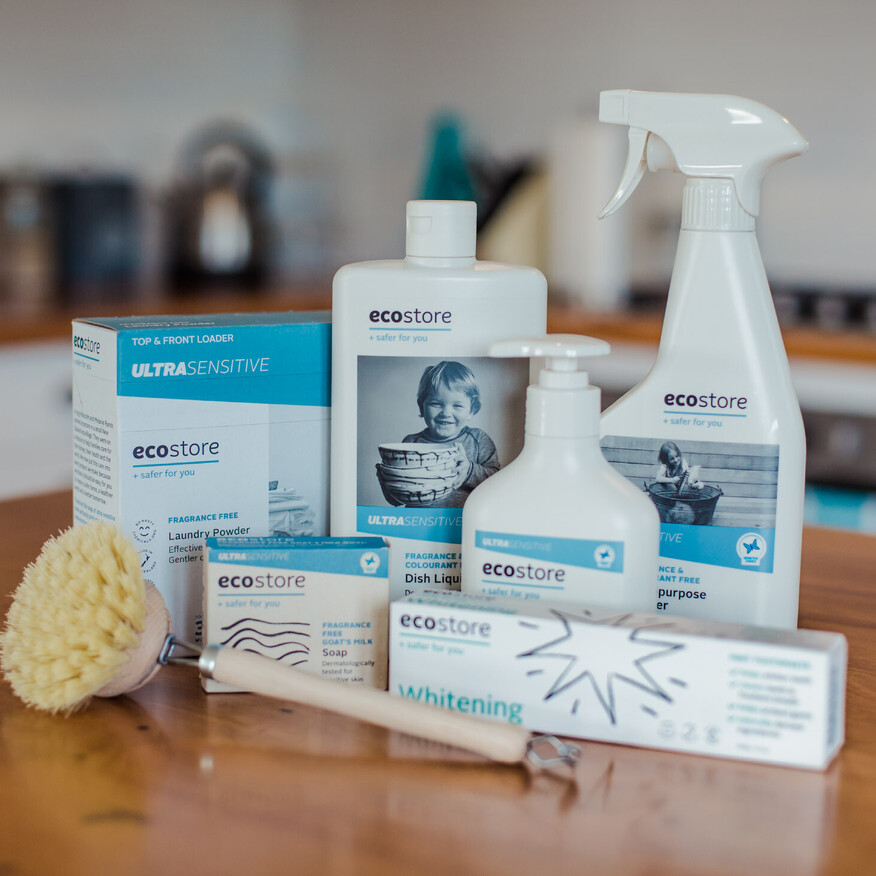 A selection of ecostore cleaning and laundry products on a wooden kitchen countertop