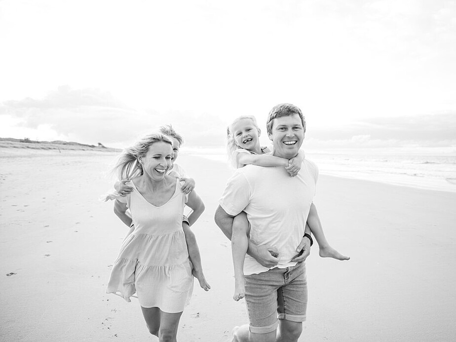 Tauranga Photographer.  Family on the beach having piggie back races.  Jackie O'Photography.  Papamoa Family Photographer.