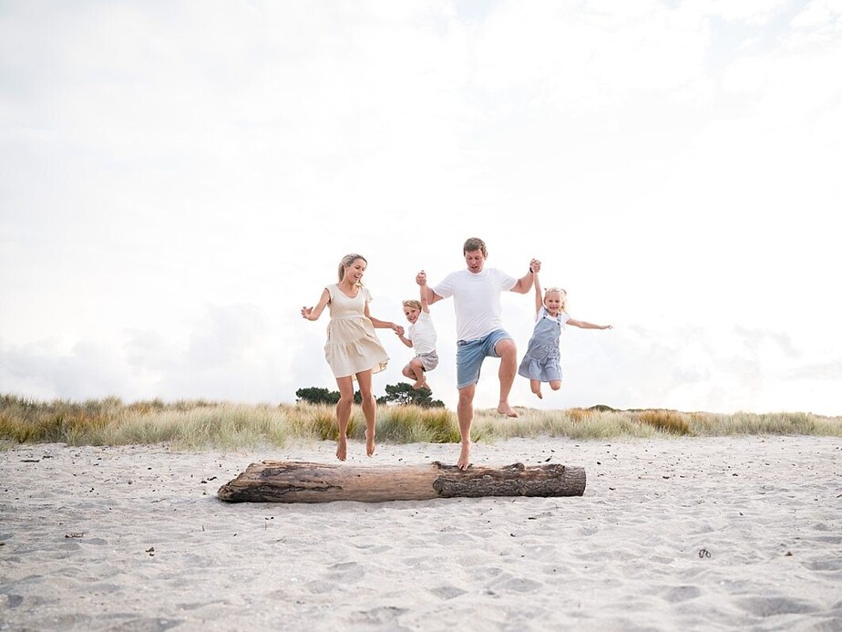 Tauranga Photographer.  Family on the beach jumping off a log.  Jackie O'Photography.  Papamoa Family Photographer.