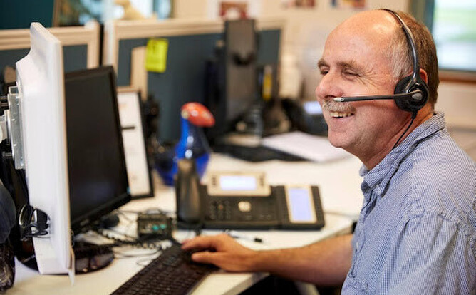 Ivan from the Blind Low Vision NZ Contact Centre team sitting ready to answer your call.
