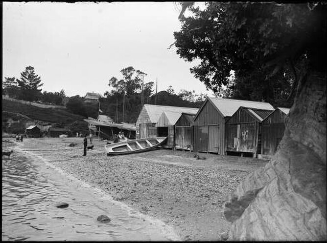 Looking east along Judges Bay beach showing boatsheds, yachts, buildings and St Stephens cemetery, left background.