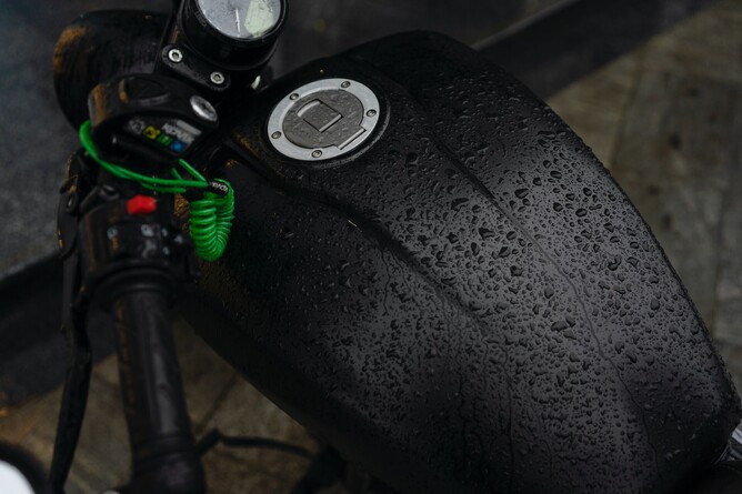 Photo of a matte black powder coated motorcycle chassis covered in rain drops