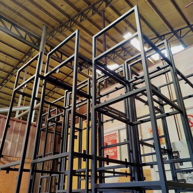 Photo of a bare shelving unit recently powder coated in gloss black at Hamilton Industrial Powder Coating