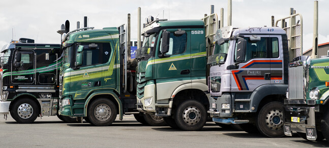 Photo of numerous logging trucks lined up in Truckworks' parking lot.