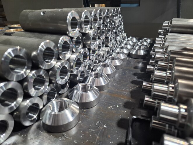 Highly polished CNC aluminium part with ribbed detailing and logo engraving.