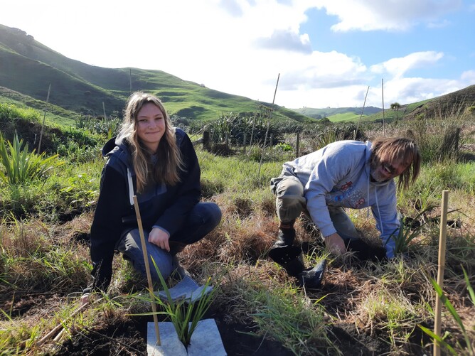 Female student and Trees for Survival plant native trees as part of the Trees for Survival school environmental education programme