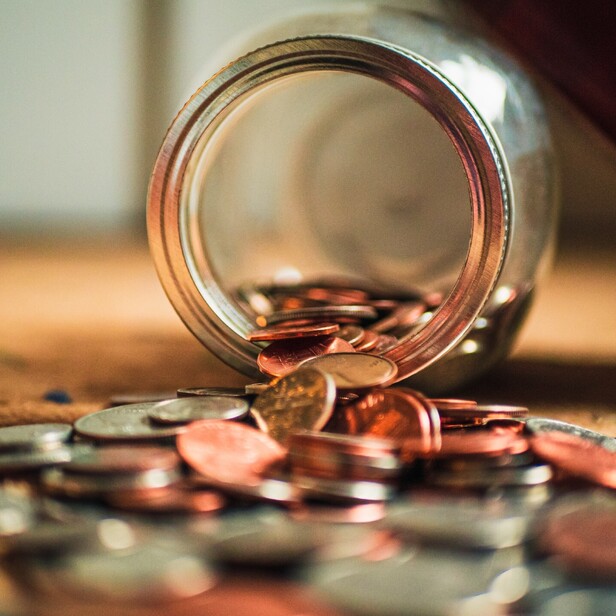 A jar on it's side with coins spilling out.