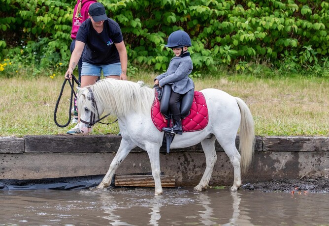 Child riding on a pony with an Inky Dinky Saddle and lead rein