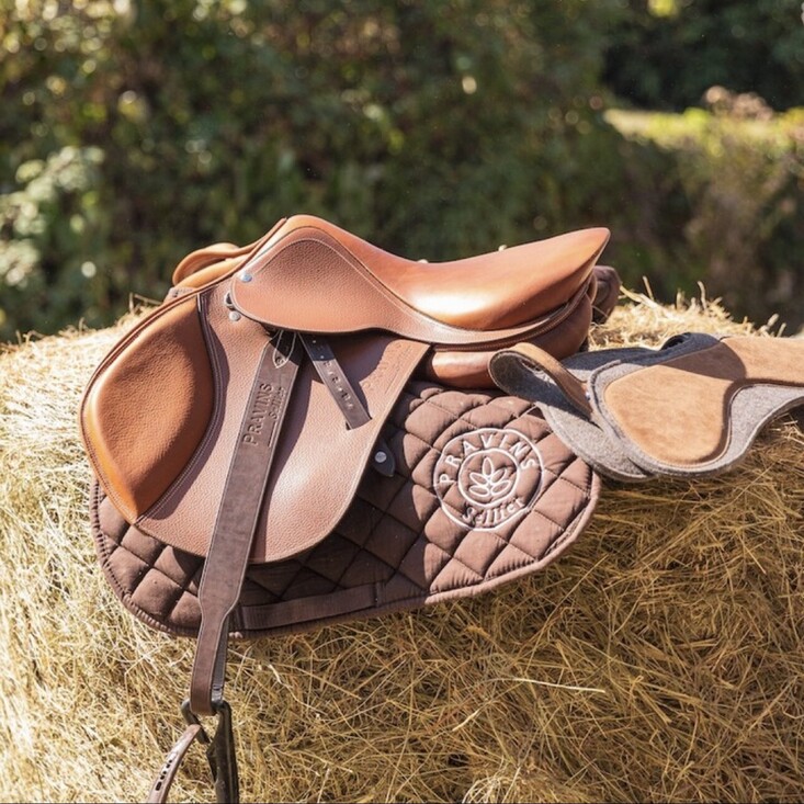 saddle with leathers on a hay bale