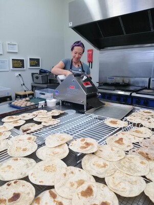 Amber making flour tortillas in the kitchen.