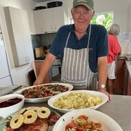 Comfort Kai image of man with plates of food on a table