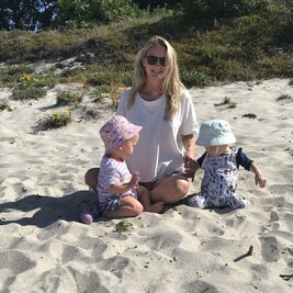 Photo of Jess on the beach with two young children