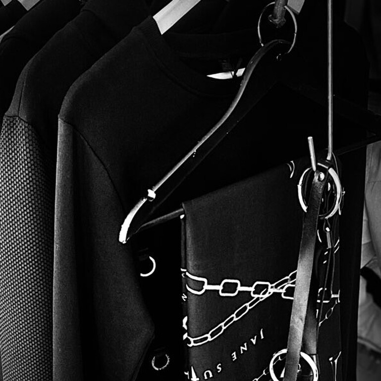 A black and white image of Jane Sutherlands garments on a hanger in her workroom.