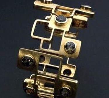 A models hands adorned with Jane Sutherlands handmade silver jewellery.