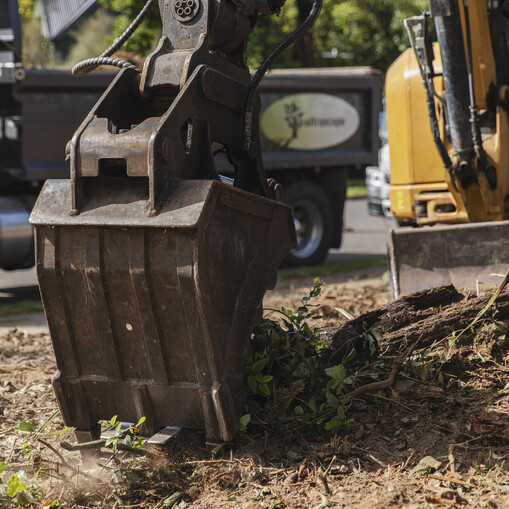 Ultrascape team using a digger to clear land for site preparation