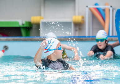 three Ace school age swimmers splashing in the pool