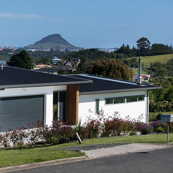 Modern home clad with white timber overlooking views of Mount Maunganui 