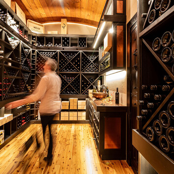 man walking through his wine cellar. 