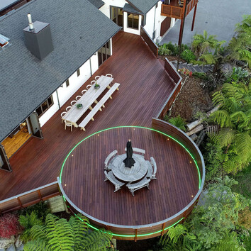 Arial view of large family home and large deck surrounded by New Zealand native bush.