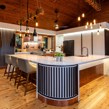 Modern white kitchen with timber flooring and timber ceiling. 