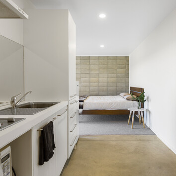 Modern home with concrete floor and concrete feature wall in the bedroom 