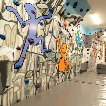 indoor climbing wall with art murals painted on the walls