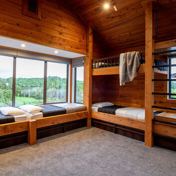 rustic timber bedroom with build in bunk beds and large window seat