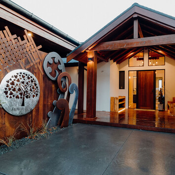 Rustic timber entranceway with metal art scupltures.
