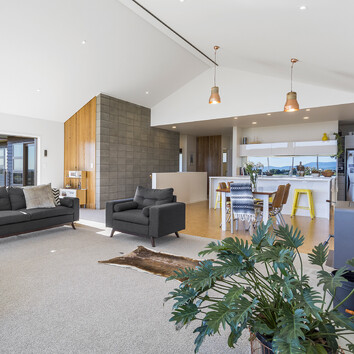 Open plan kitchen dining and lounge area. Modern design with high pitched a-frame ceiling.