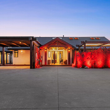 Home exterior illuminated with red outdoor lighting