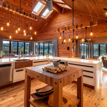 beautiful open plan kitchen with timber walls an high pitched ceiling