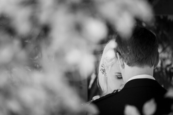 wedding couple blacka nd white photography with blury fourground showing brides DIY earings