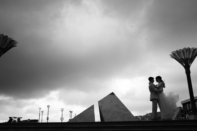 Blacka nd white photograph of bride and groom on wellington's civi square steps on a stormy day