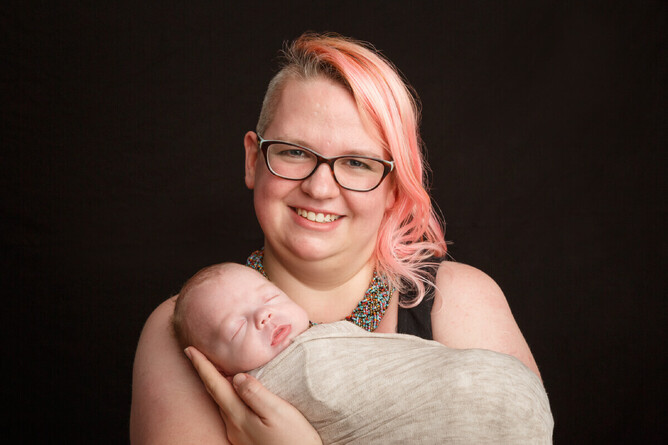 photograph of a newborn in his mother armes in the mel waite photography studio
