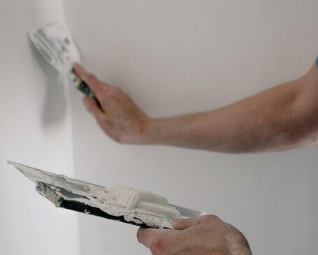 Worker plastering a wall