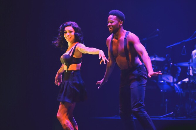 Two performers dance on stage