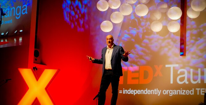 Man speaking on stage at TEDxTauranga