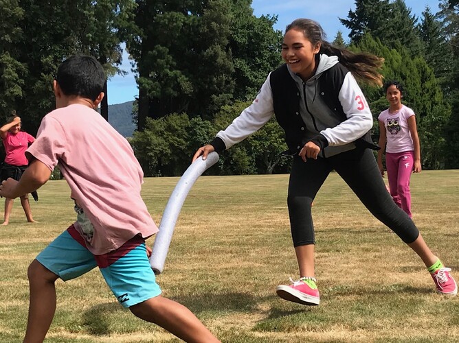 Girl chases boy with foam stick in game