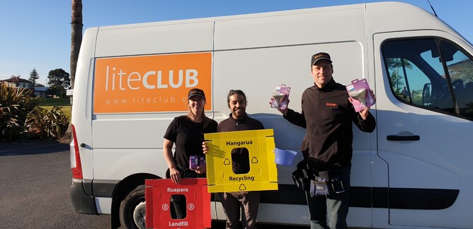 Three LiteClub staff stand by van holding energy efficient light bulbs and recycling bin lids