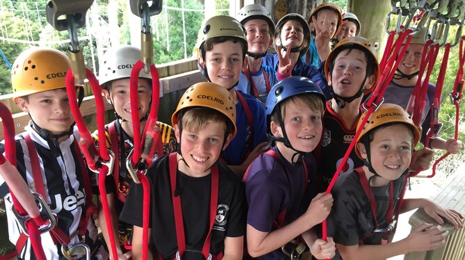 12 children in harnesses and helmets smile for photo