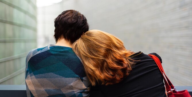 Woman leans on shoulder of person