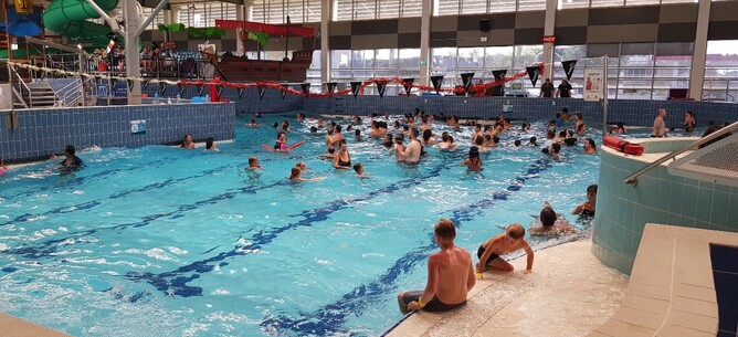 People sitting in wave pool inside Baywave