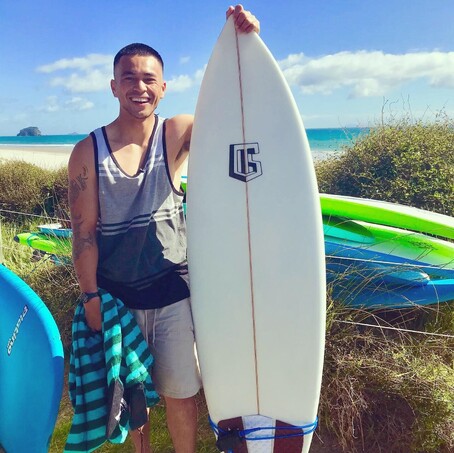 Jared Dixon with his surfboard