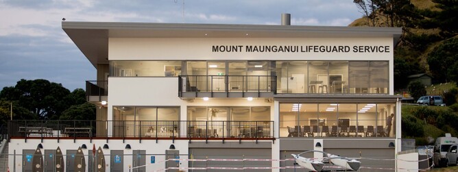 Front of Mount Maunganui Lifeguard Service building lit up inside