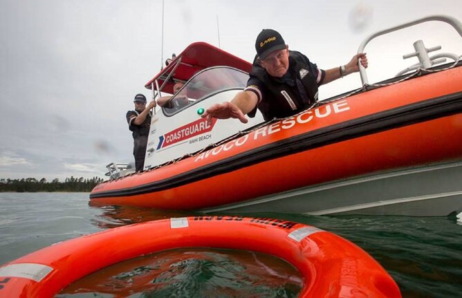 Man reaches to grab buoy ring in water