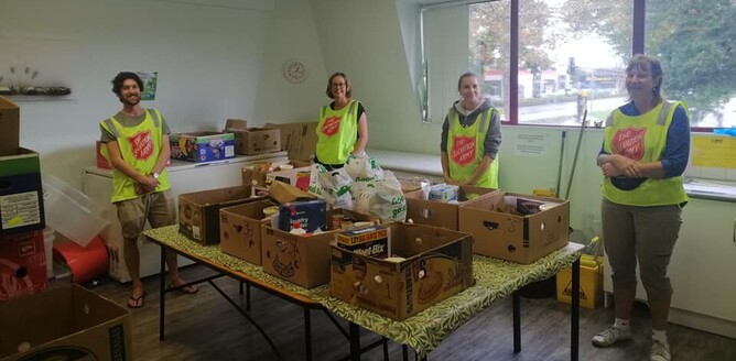 Salvation Army volunteers stand with food parcels
