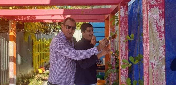 TECT Trustee Peter Blackwell paints the new pergola with a student
