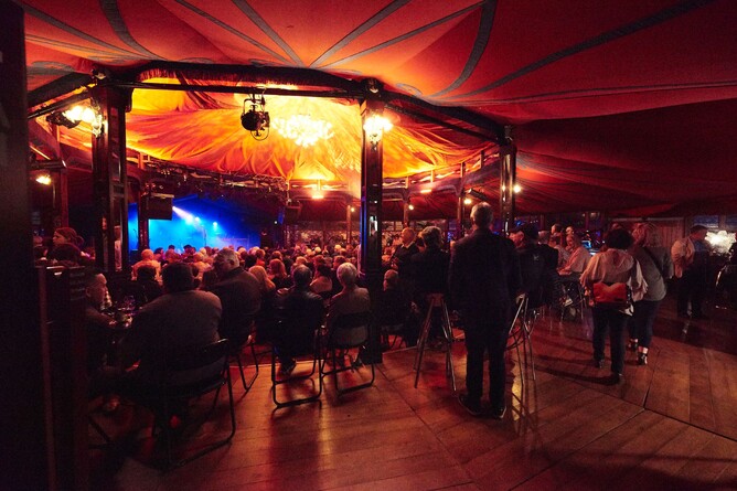 Audience members sit in tent of Carrus Crystal Palace